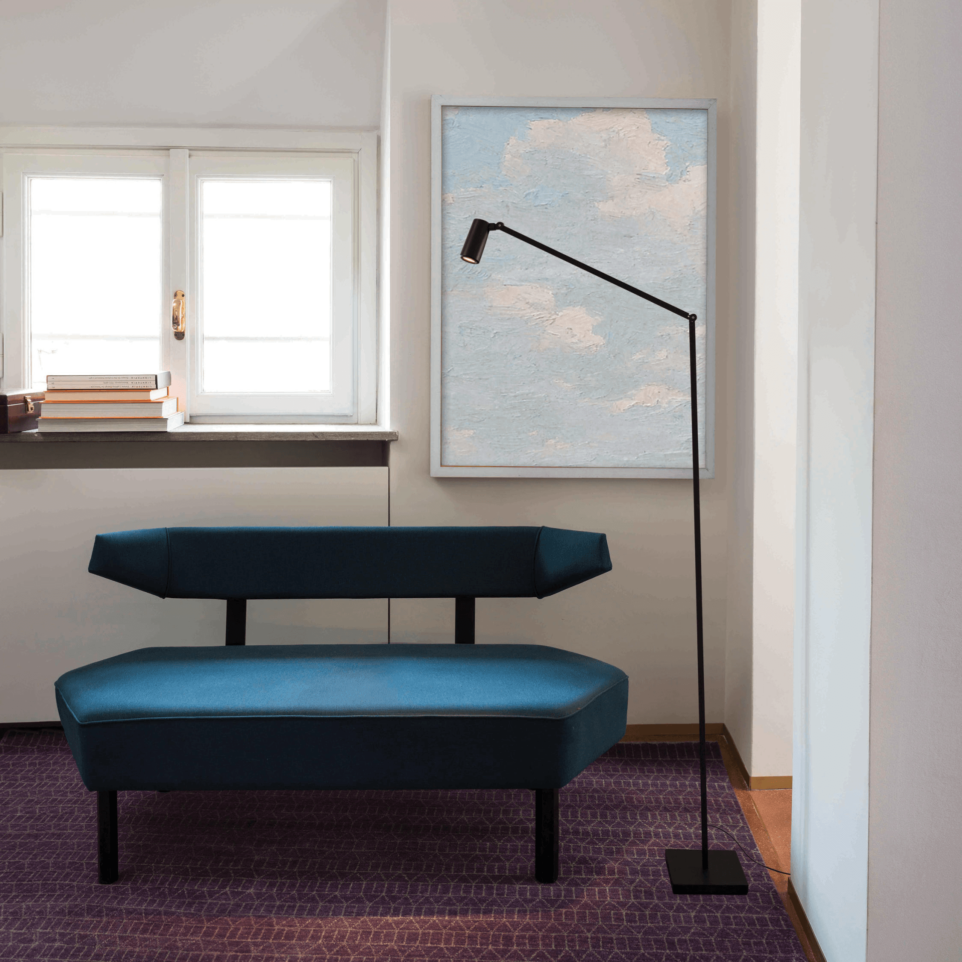 Una sala de estar con un sofá azul y una lámpara.