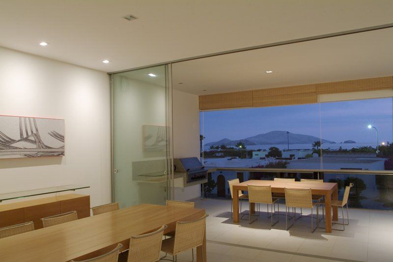Un comedor con mesa y sillas y una gran ventana.