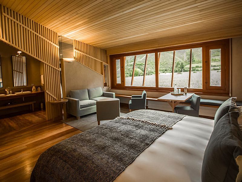 Una habitación de hotel con una cama grande, un sofá, sillas y una mesa.