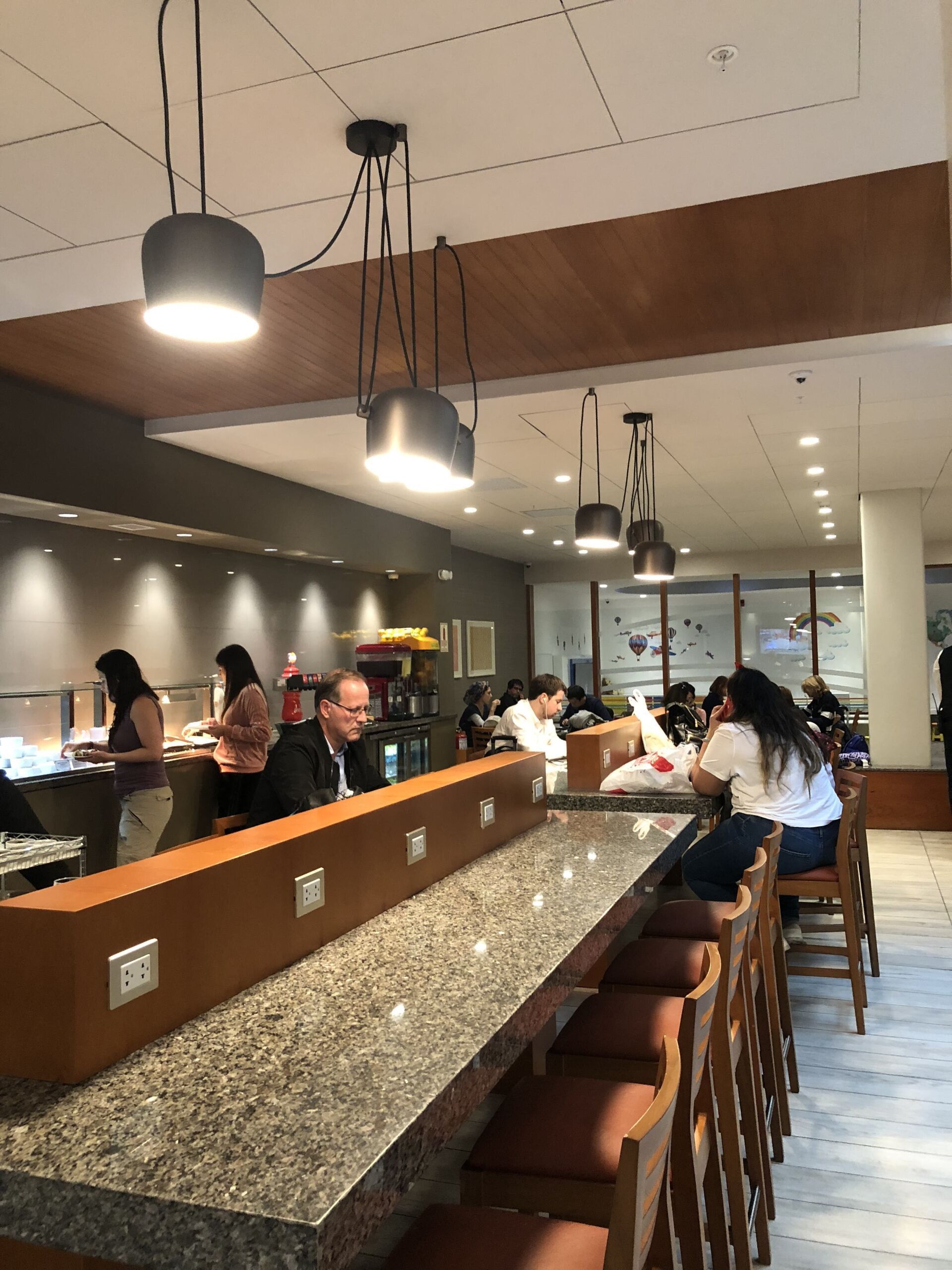 Un grupo de personas está sentado en una mesa larga en un restaurante.
