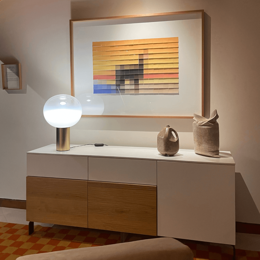 Una sala de estar con una lámpara y un cuadro en la pared.