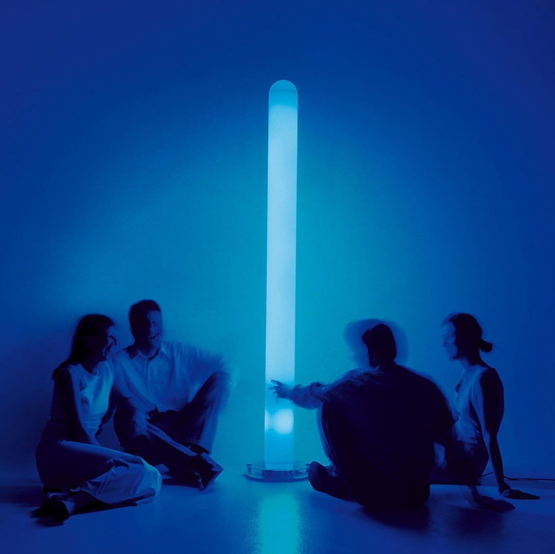 Un grupo de personas está sentada frente a una luz azul.