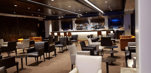 Una gran sala llena de sillas, mesas y un bar.