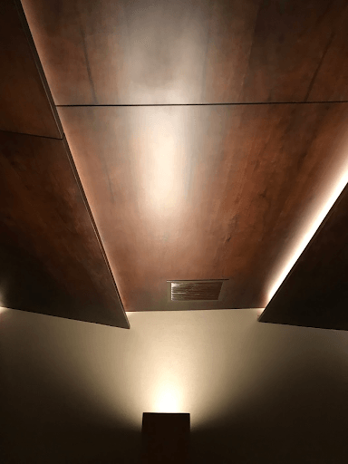 Un techo de madera con una luz brillando a través de él.