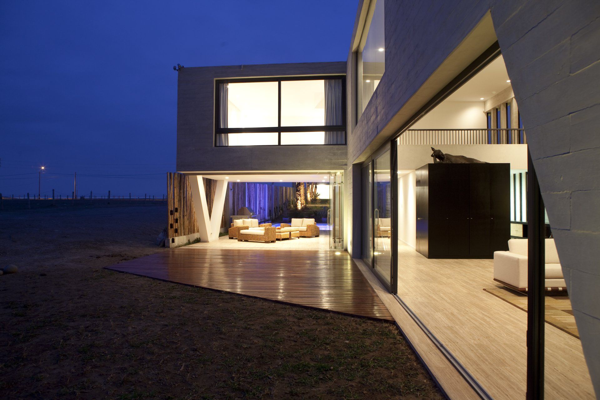 Una casa con muchas ventanas está iluminada por la noche.