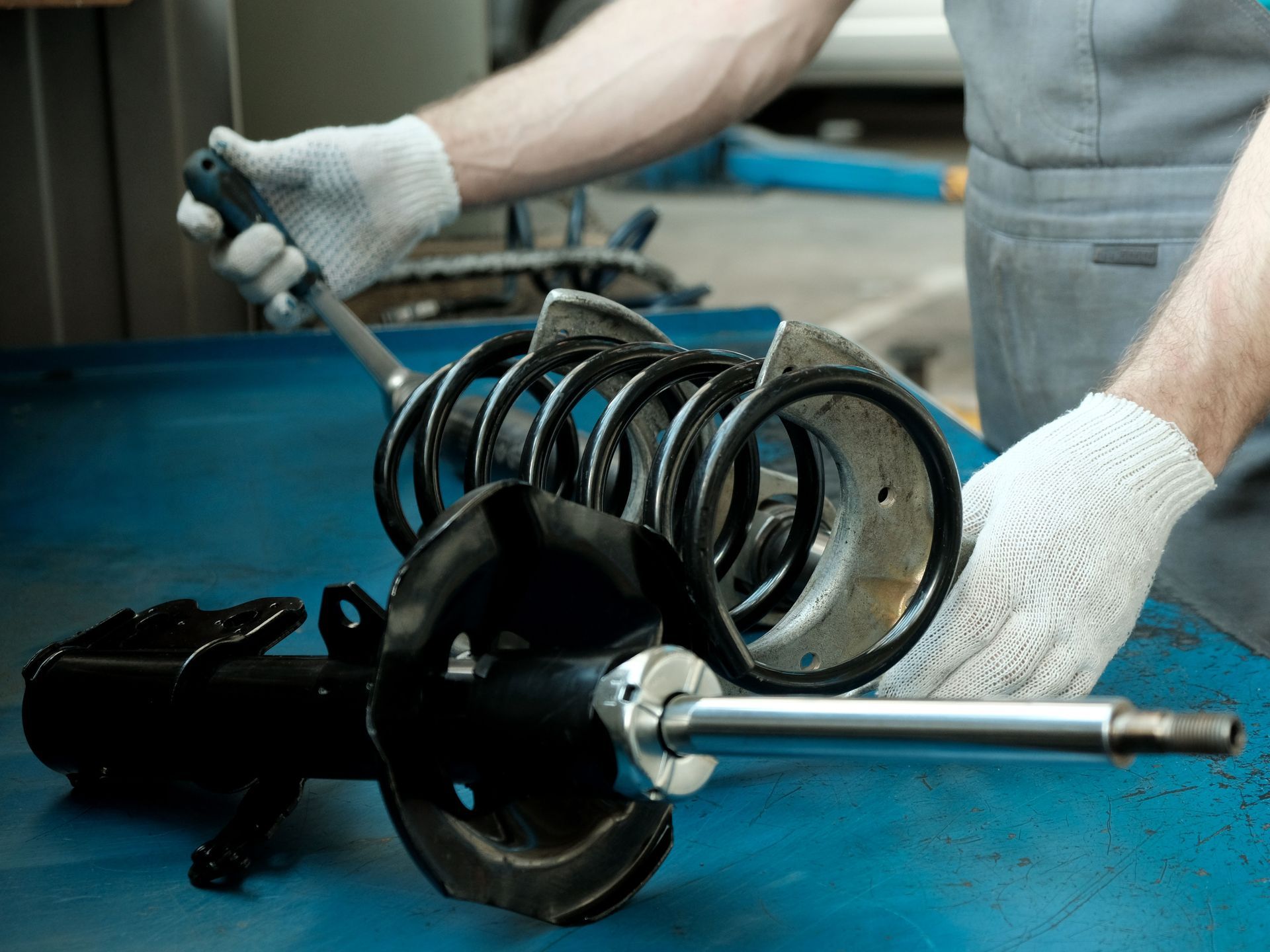 Technician working on a suspension car part | Family AutoCare & Repair