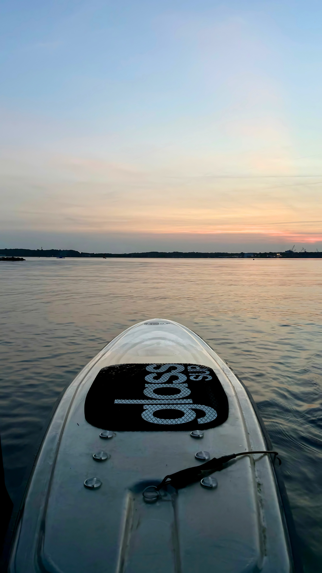 Bei Sonnenuntergang schwimmt ein glassSUP auf der Wasseroberfläche.