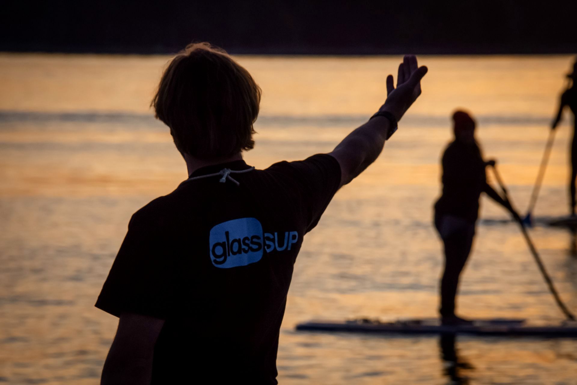 Ein Mann mit einem Glasscup-Shirt steht im Wasser.