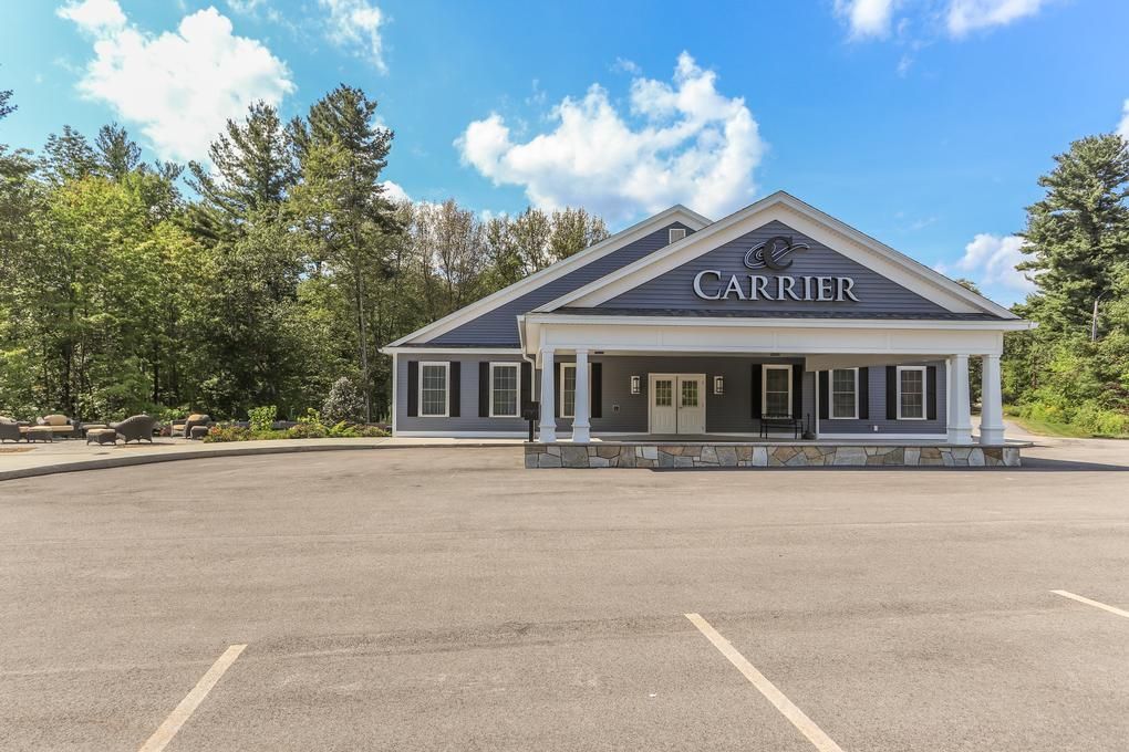 Carrier-branded storefront with gray exterior and empty parking lot under a blue sky