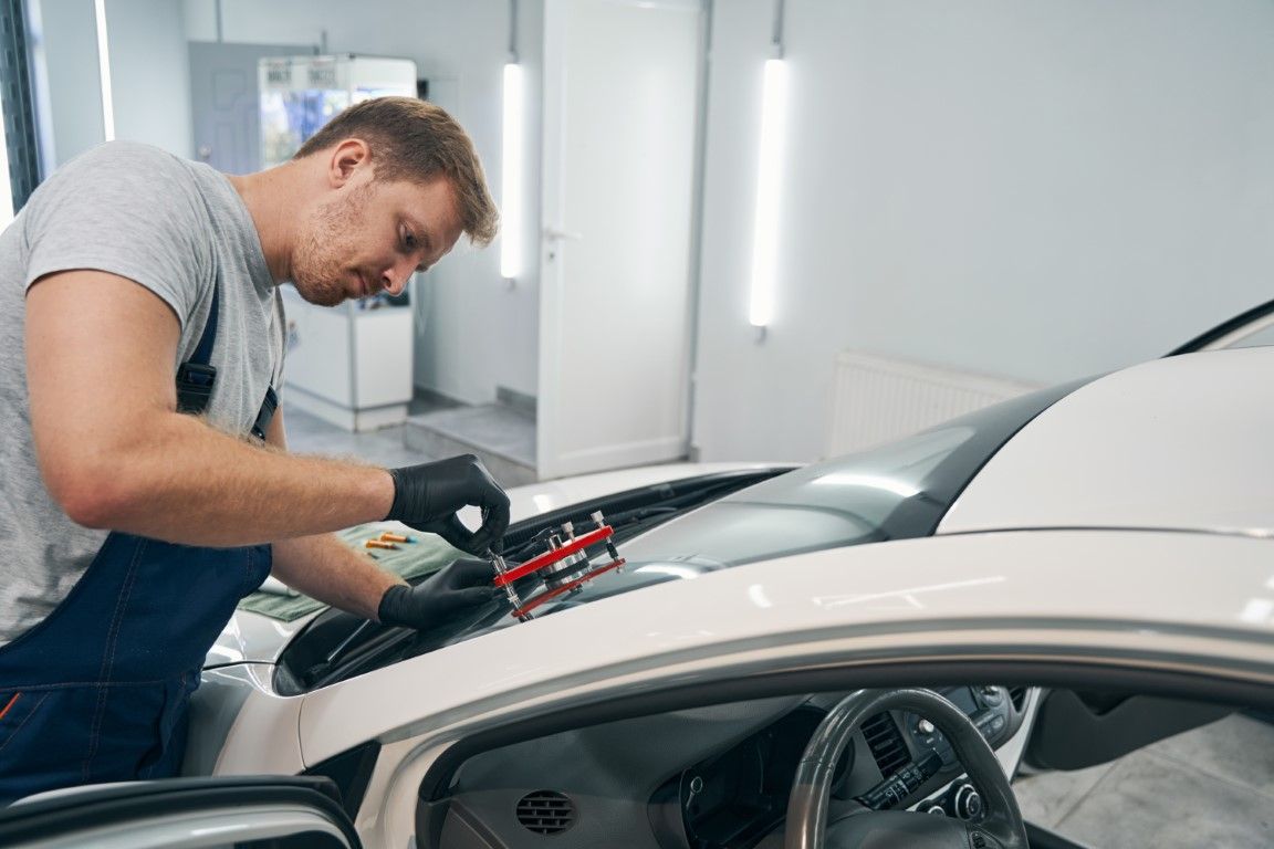 Mechanic inspecting a car engine in a bright auto repair shop