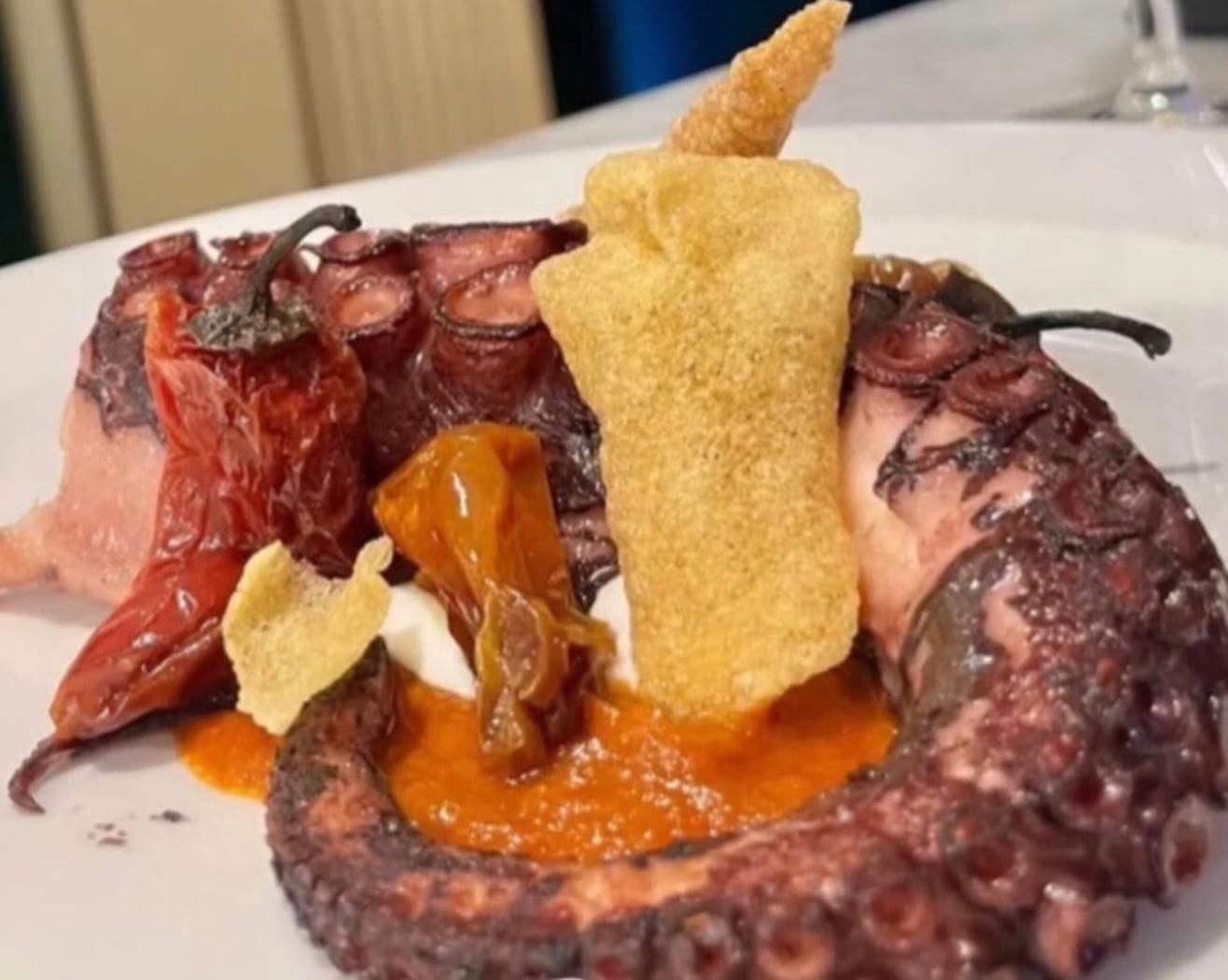 Un piatto bianco sormontato da un pezzo di cibo e salse