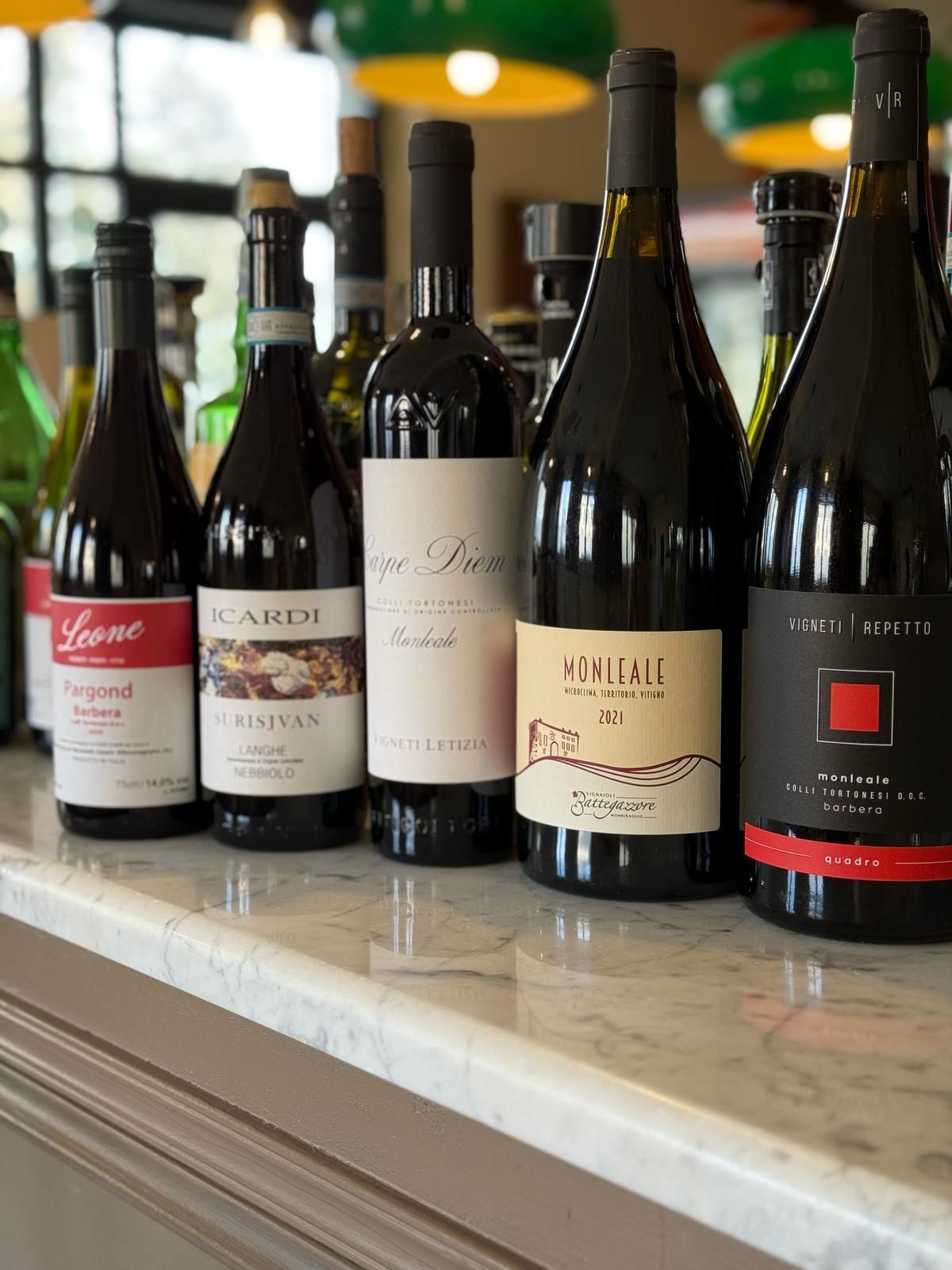 Diverse bottiglie di vino sono allineate su un bancone