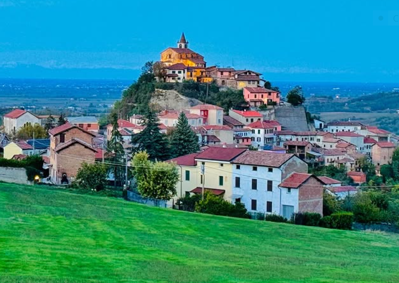 Una piccola città in cima a una collina con una cupola in cima