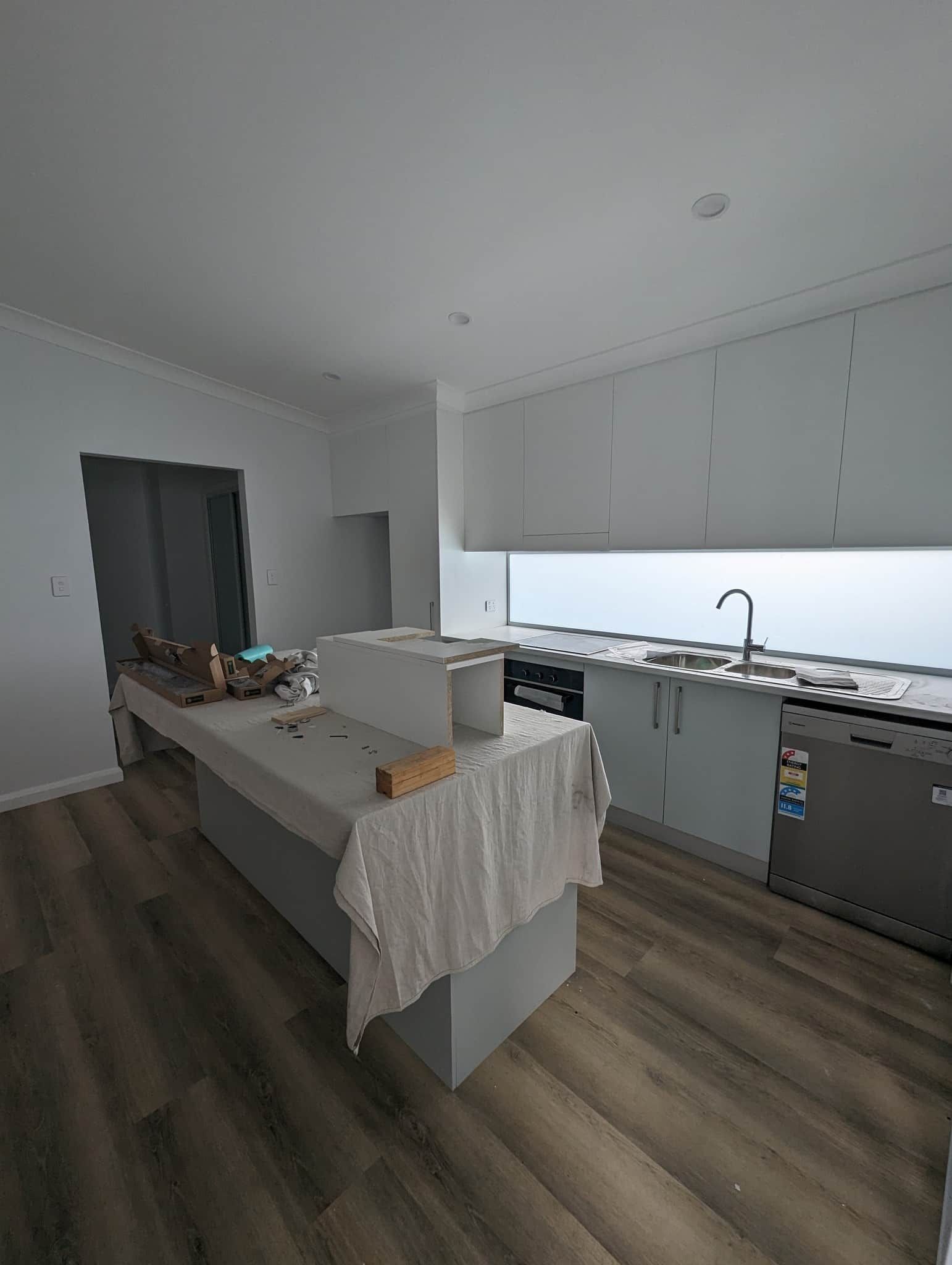 A Kitchen With A Large Island In The Middle Of The Room — Renovate A Space In Empire Bay, NSW
