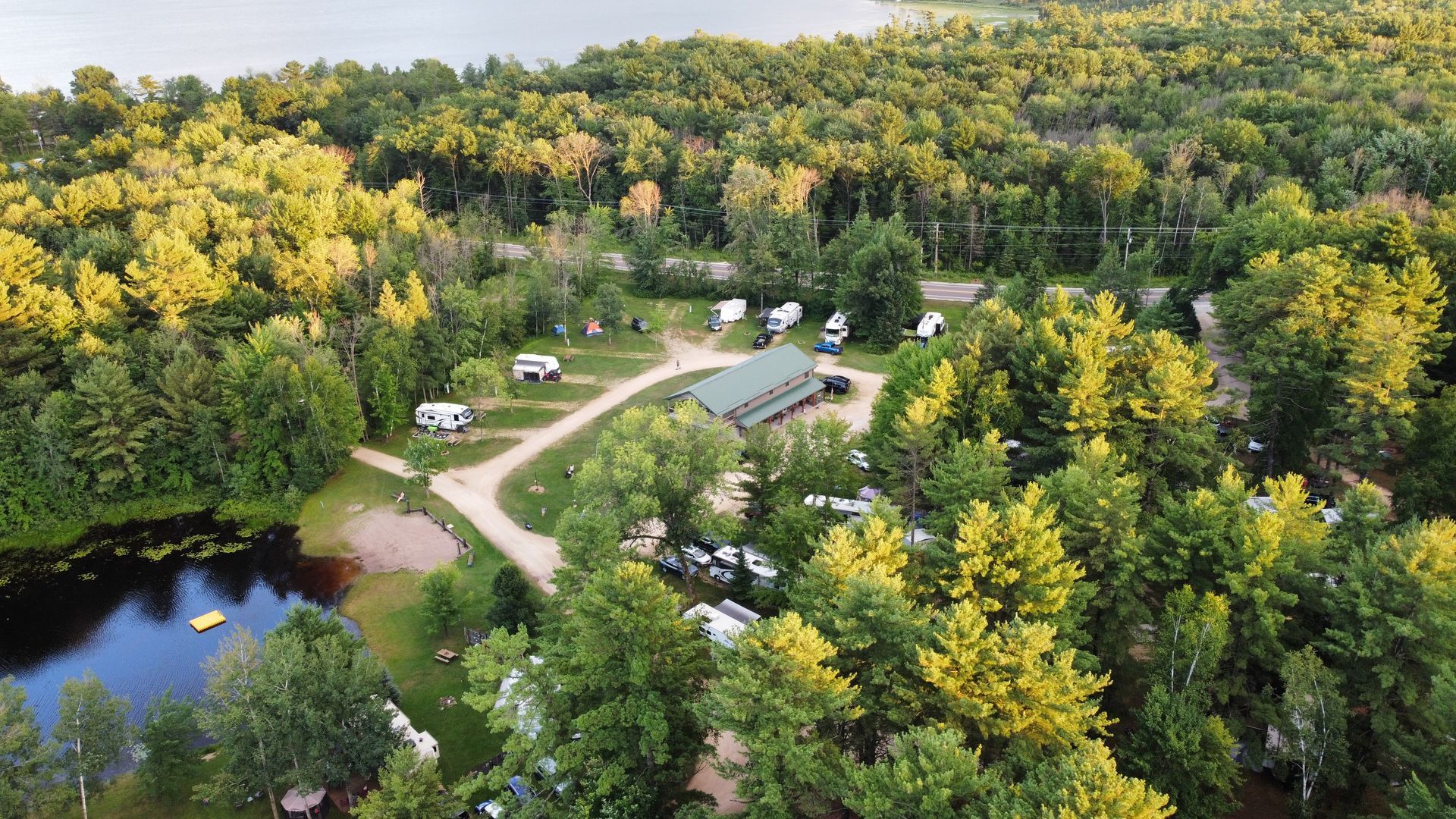An aerial view of a campground surrounded by trees and a lake.