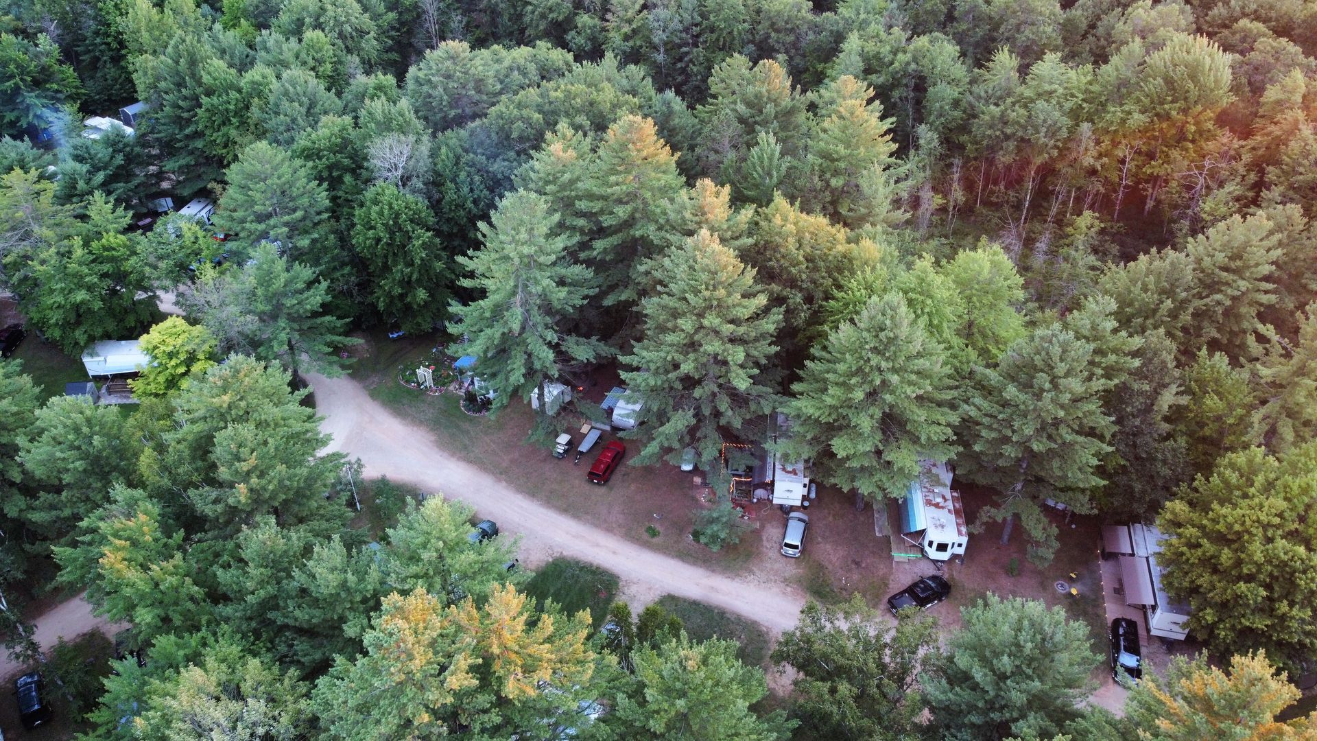 An aerial view of a fawn lake  campground in the middle of a forest.