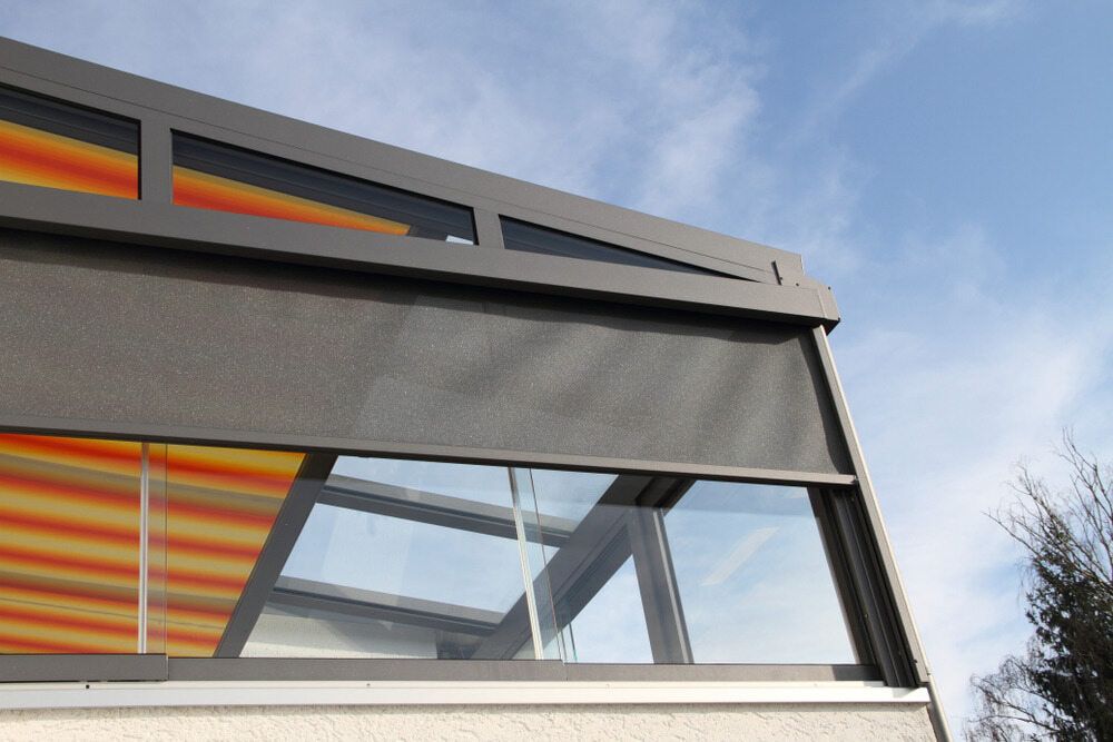 A Building With a Striped Awning on the Side of It — Maxview Blinds and Shutters in Beresfield, NSW