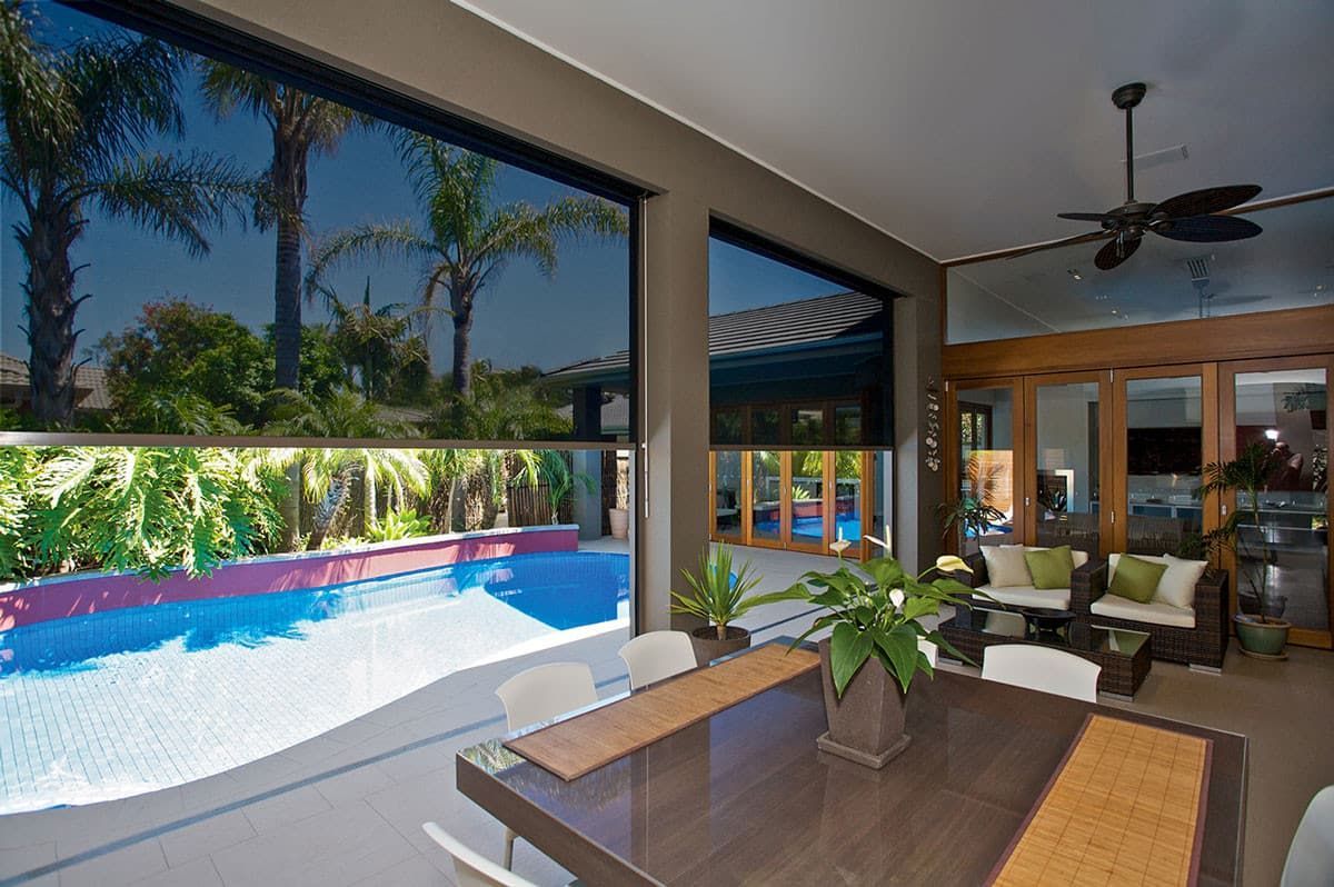 Covered patio with Ziptrak blind, wicker chair, and view of a small backyard — Maxview Blinds and Shutters in Beresfield, NSW