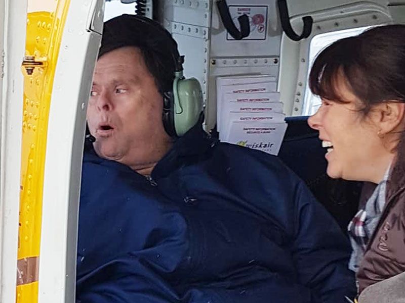 A man wearing headphones is sitting next to a woman