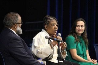 Dr. Cassandra Gould speaks while panelists NAACP President Nimrod Chapel, Jr. and ACLU Policy Director Tori Schaefer look toward her.