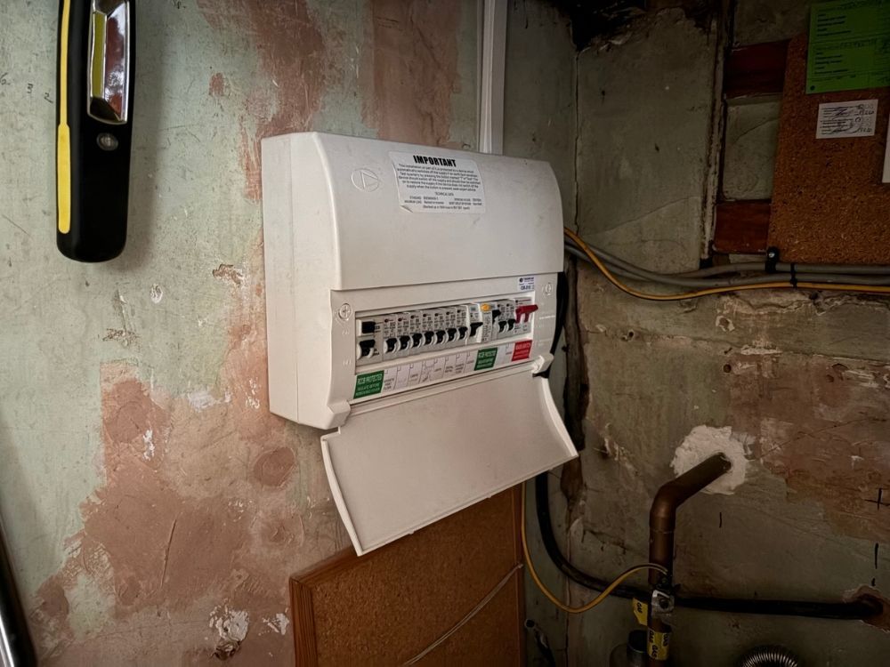 Consumer unit with RCD protection and a labelled circuit chart in an under-stairs cupboard