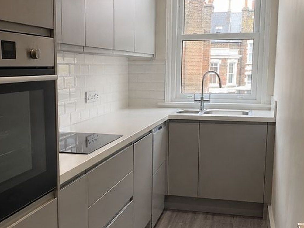 White metro tile splashback along the worktop and sink in a galley kitchen