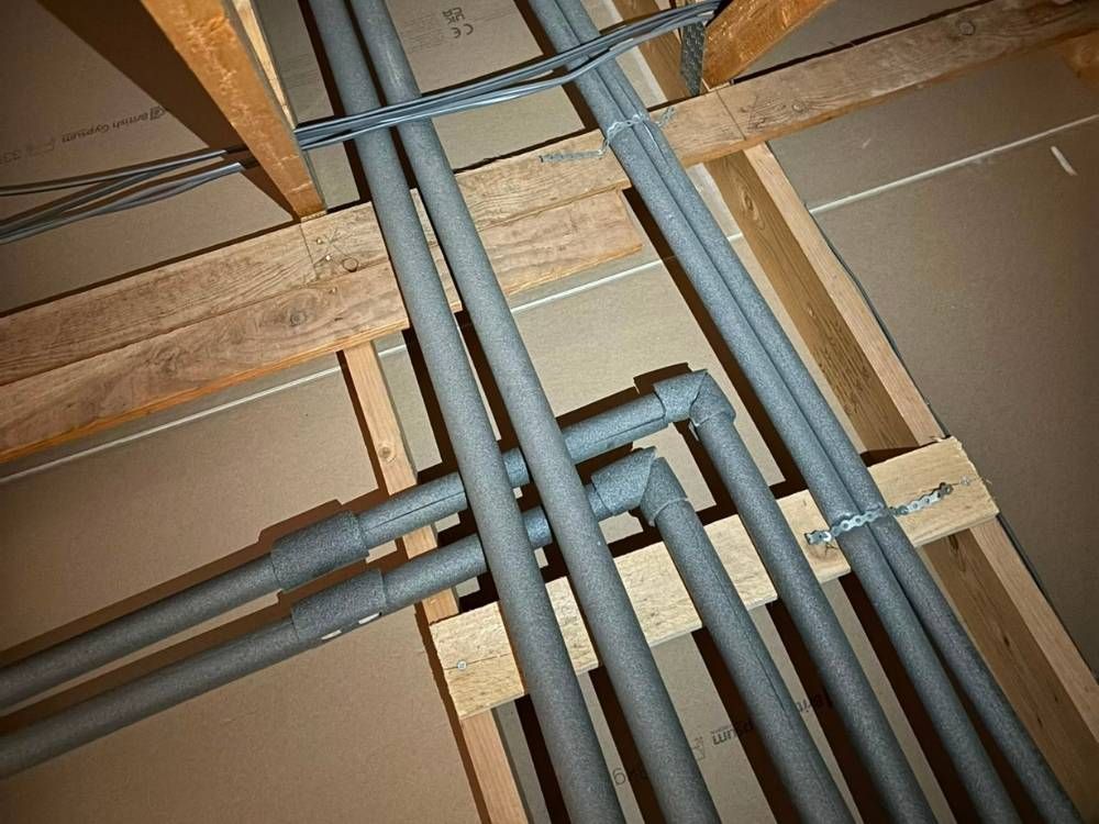 First fix pipework run neatly through timber joists before the floor goes down
