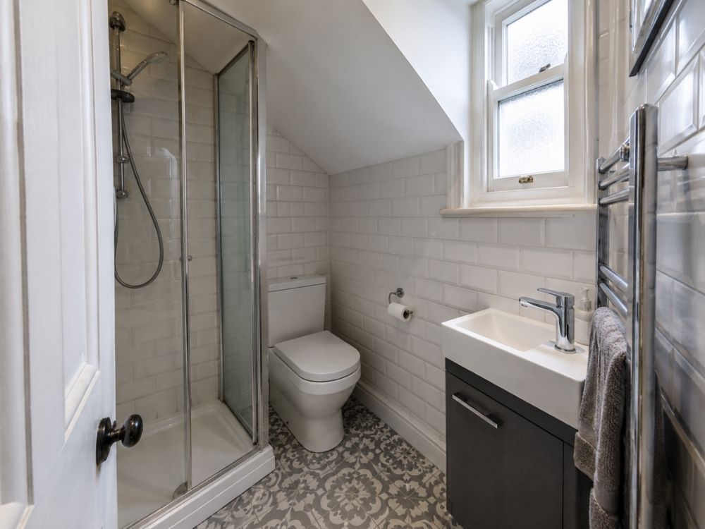 Compact bathroom with corner shower and metro tiling in a Victorian terrace