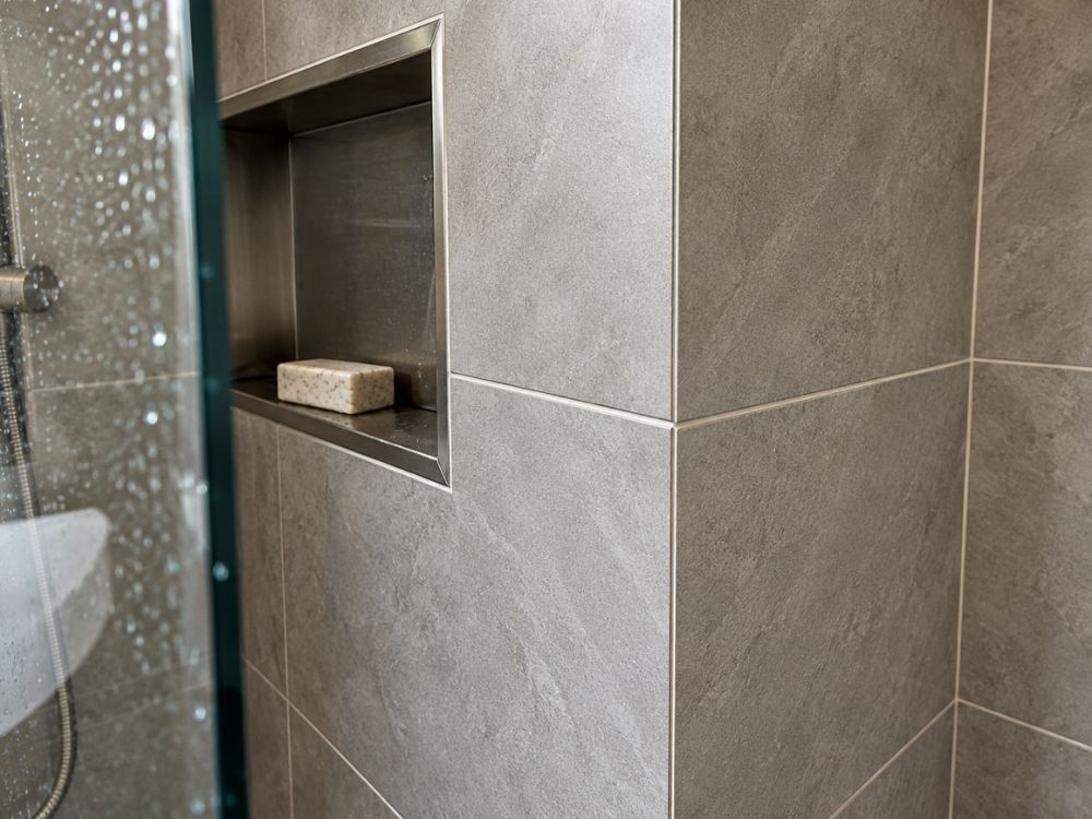 Mitred corner detail on large format porcelain shower tiling with a recessed niche