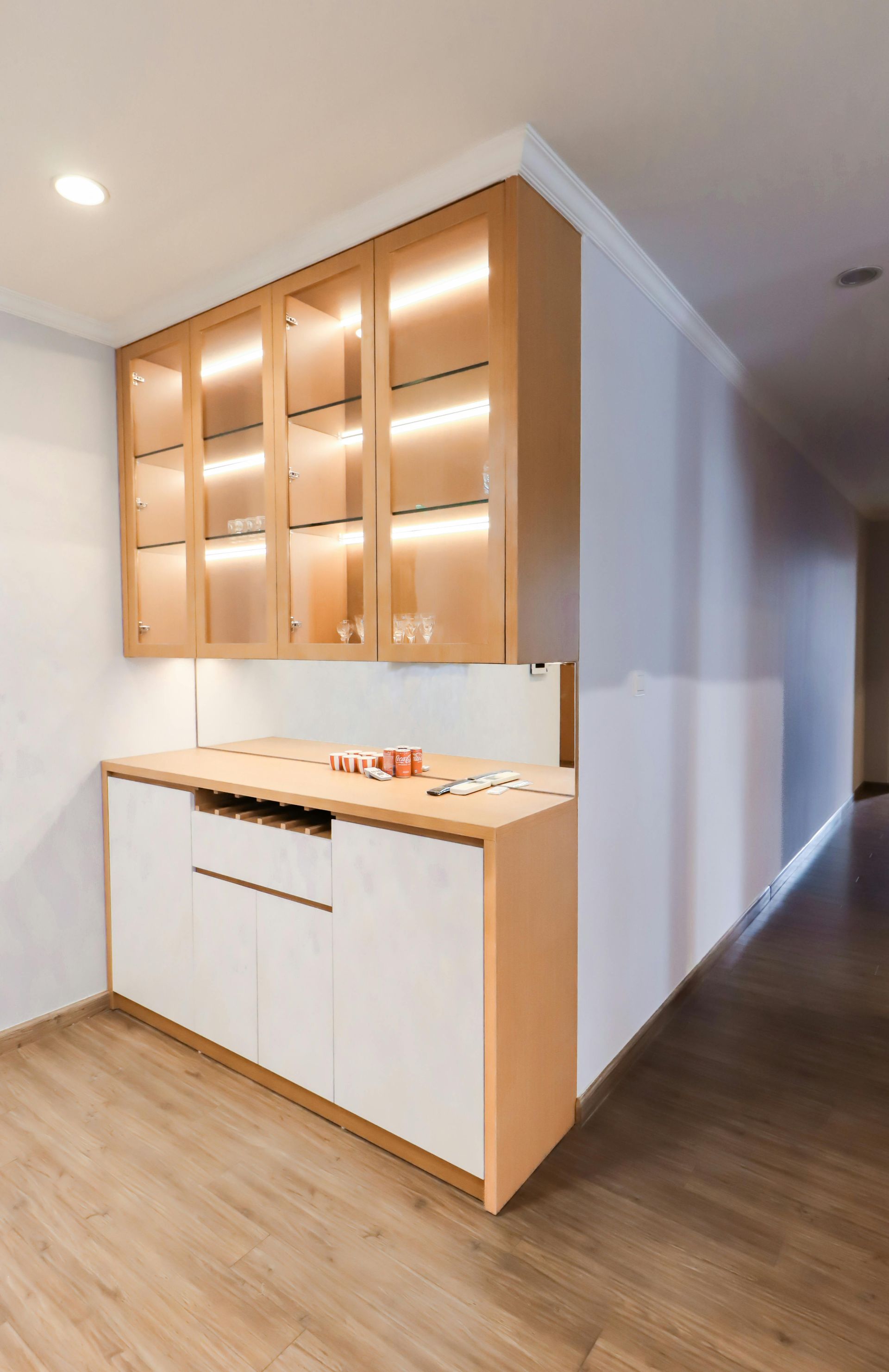 Built-in kitchen cabinetry with warm wood upper cabinets and white lower cabinets along a hallway — Tyrone Building Solutions in Anna Bay, NSW