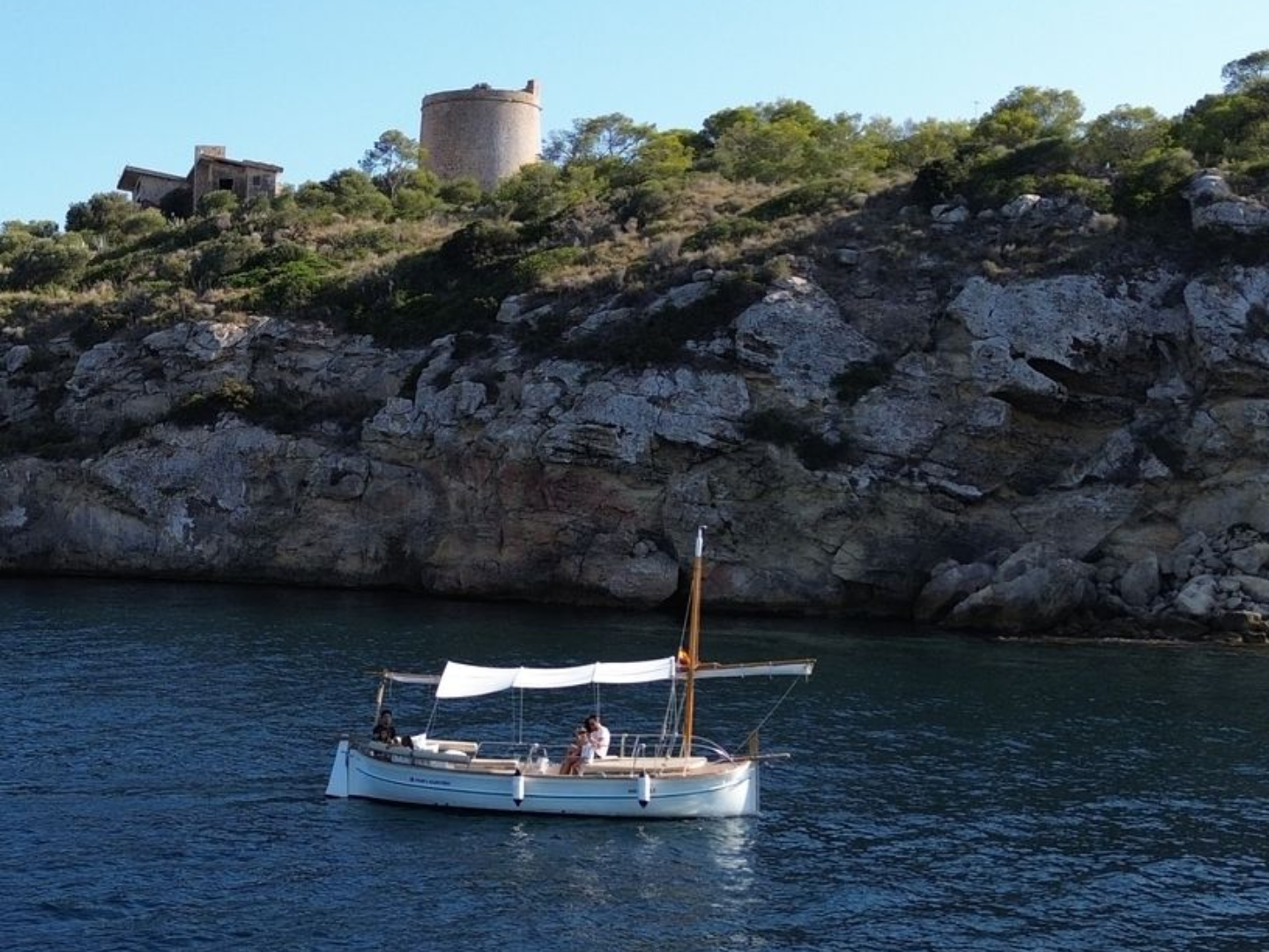 Pareja disfrutando de un romántico paseo en llaut por el mar de Mallorca, ideal para alquiler de llaut.