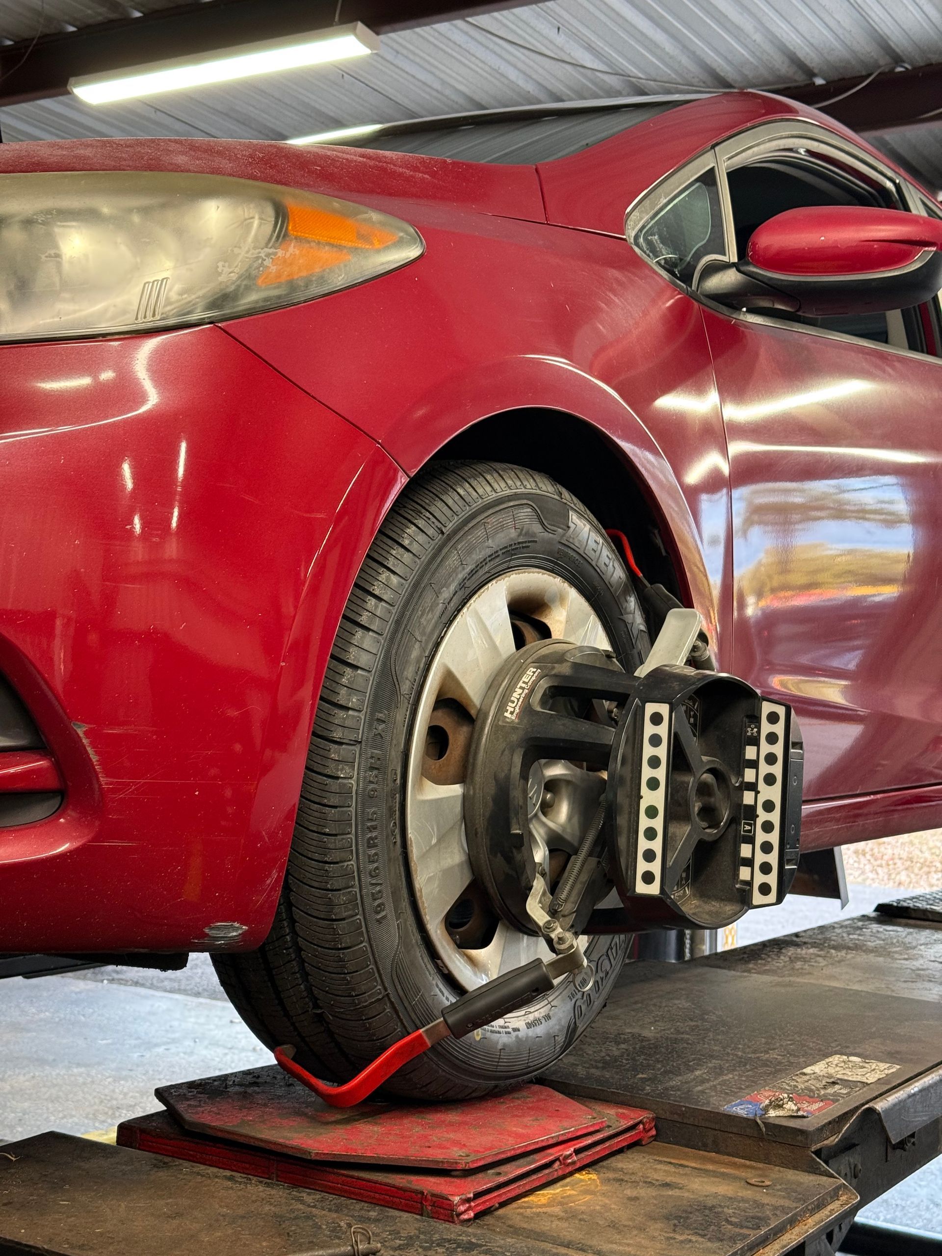 Auto shop garage with two vehicle chassis and axles on the floor near an open bay door | Eagle Tires