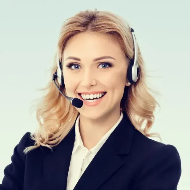 Un addetto al servizio clienti sorridente, con le cuffie e un blazer scuro, su uno sfondo chiaro.