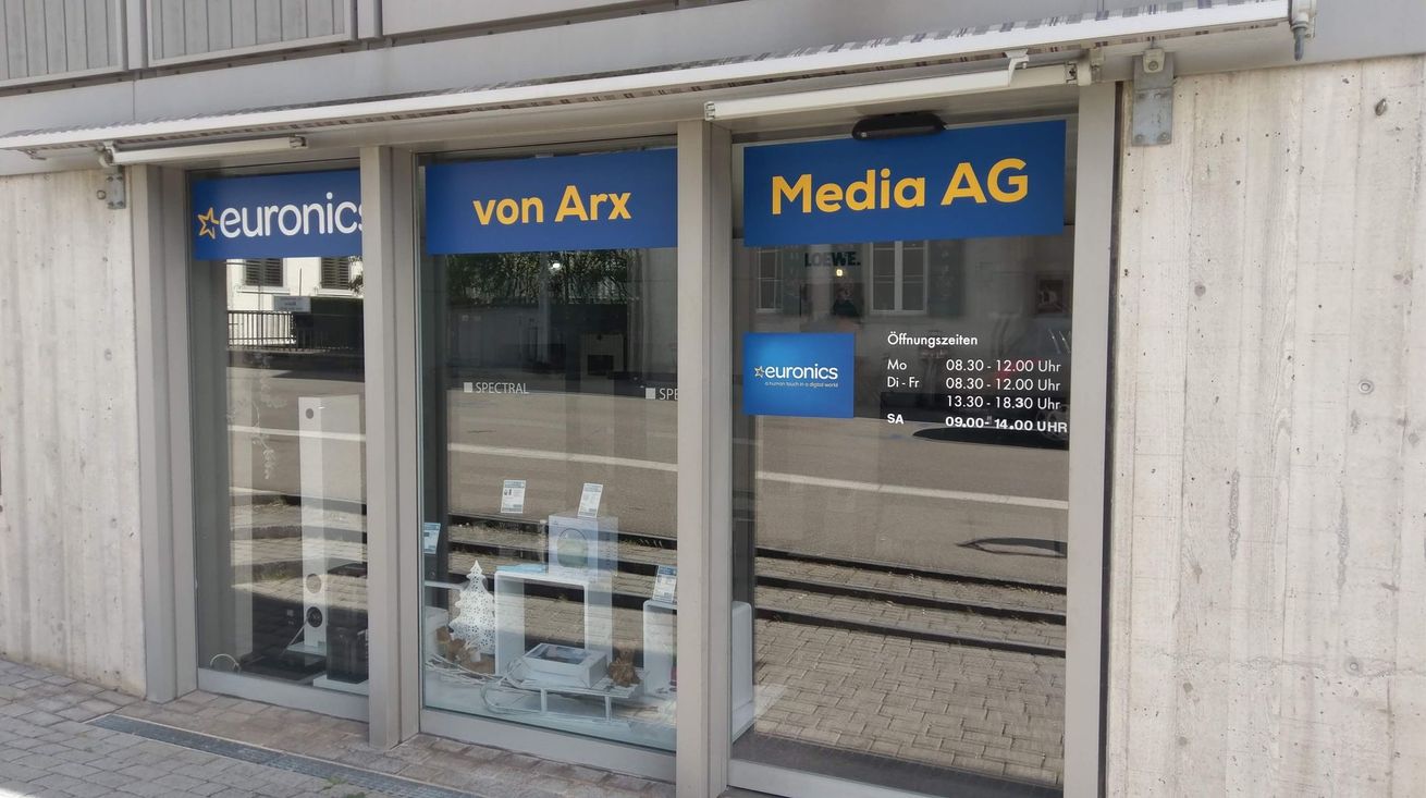 Schaufenster mit Glastüren und blauen Schildern mit der Aufschrift „euronic“, „von Arx“ und „Media AG“