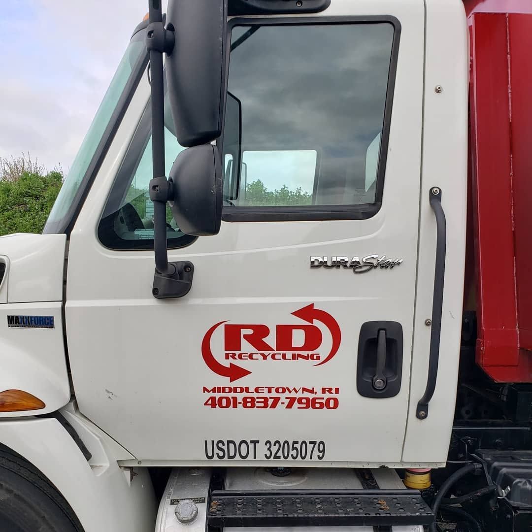 White and red R&D Trucking semi cab door with company logo and USDOT number visible