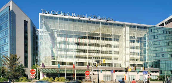 A large building with a lot of windows and a stop sign in front of it.