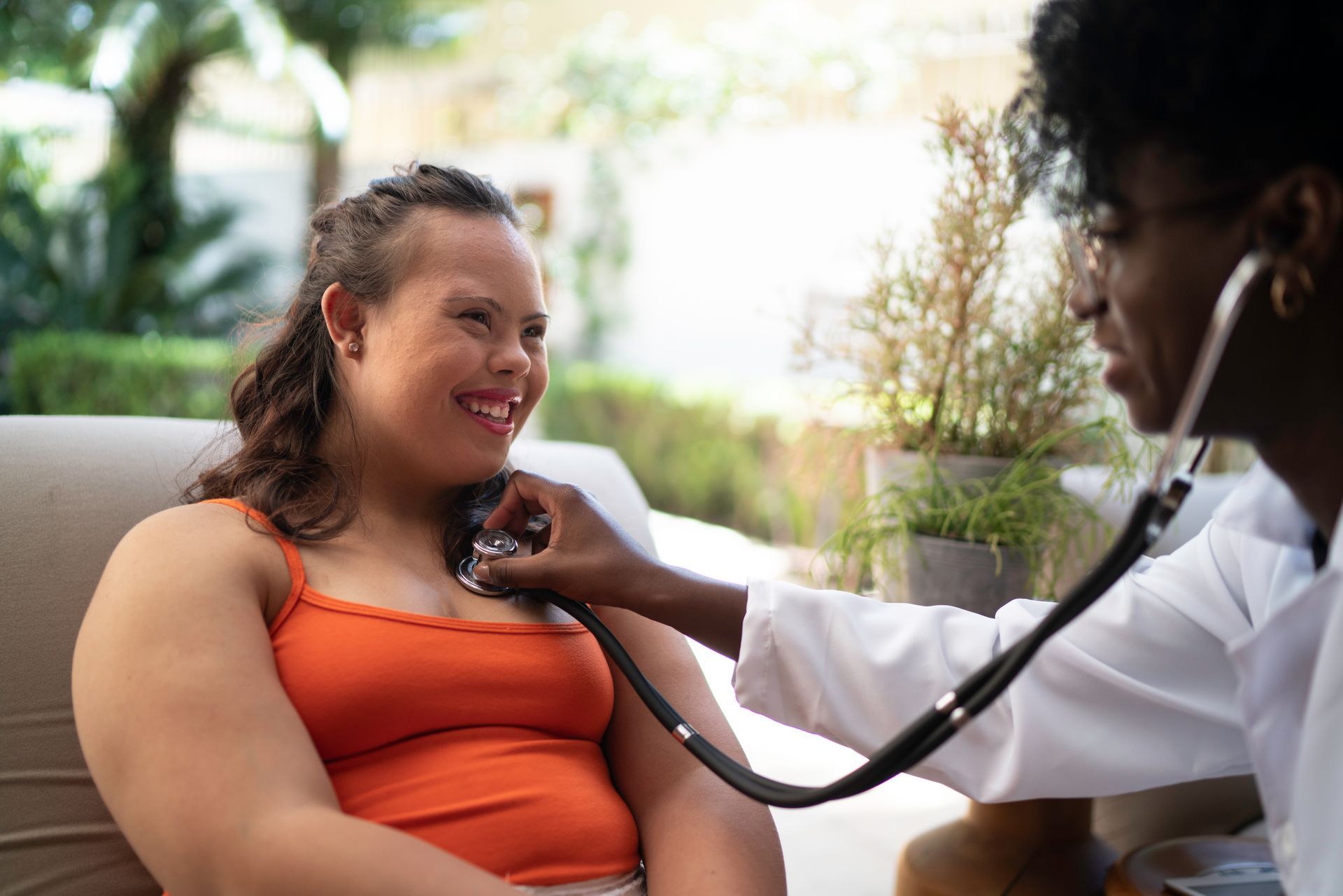 A doctor is listening to a woman 's heart with a stethoscope.