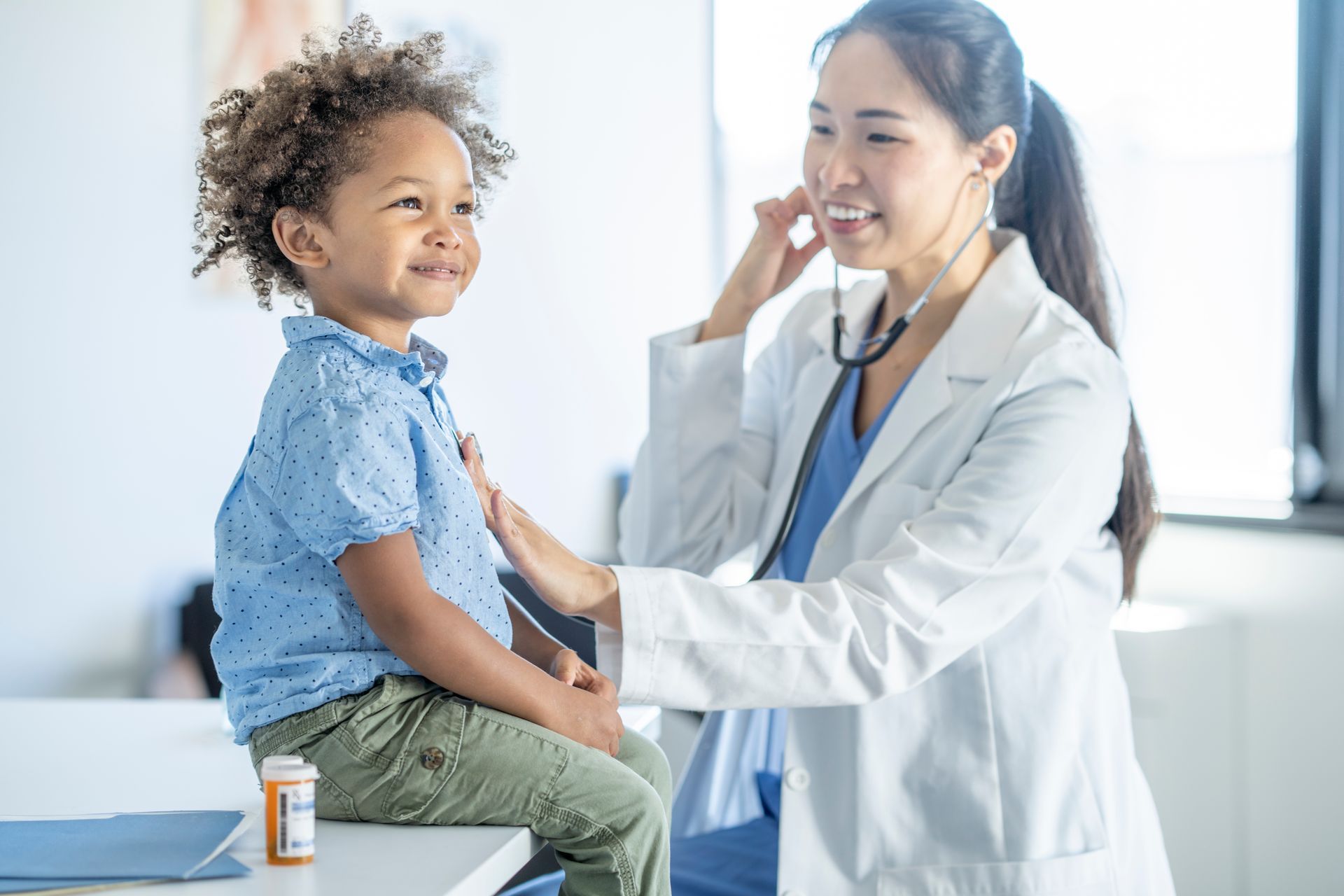 A doctor is examining a young boy with a stethoscope.