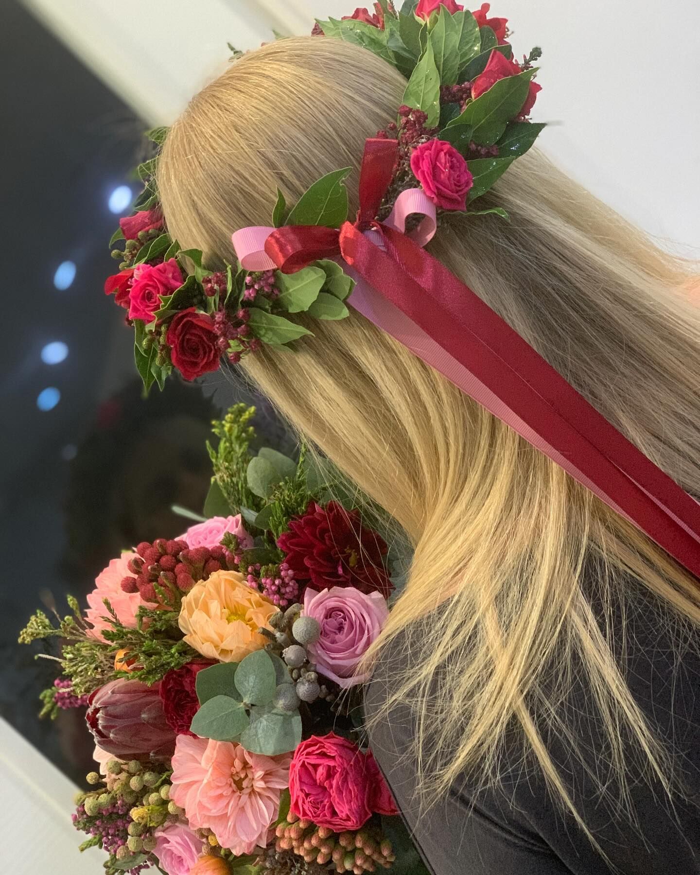 Una donna indossa una corona d'alloro per la festa di laurea che tiene in mano un mazzo di fiori.
