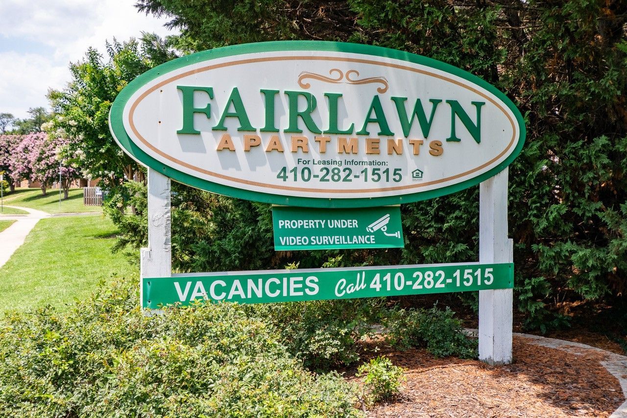 Fairlawn Apartments sign in green and white with phone number and vacancies notice.