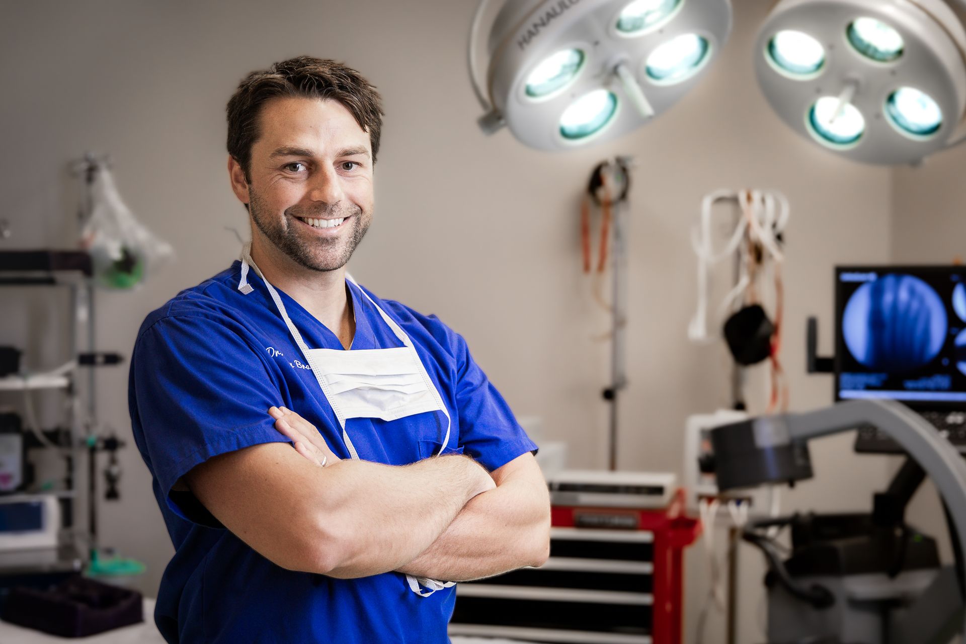 A man in an operating room with his arms crossed