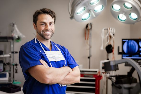 A man in an operating room with his arms crossed