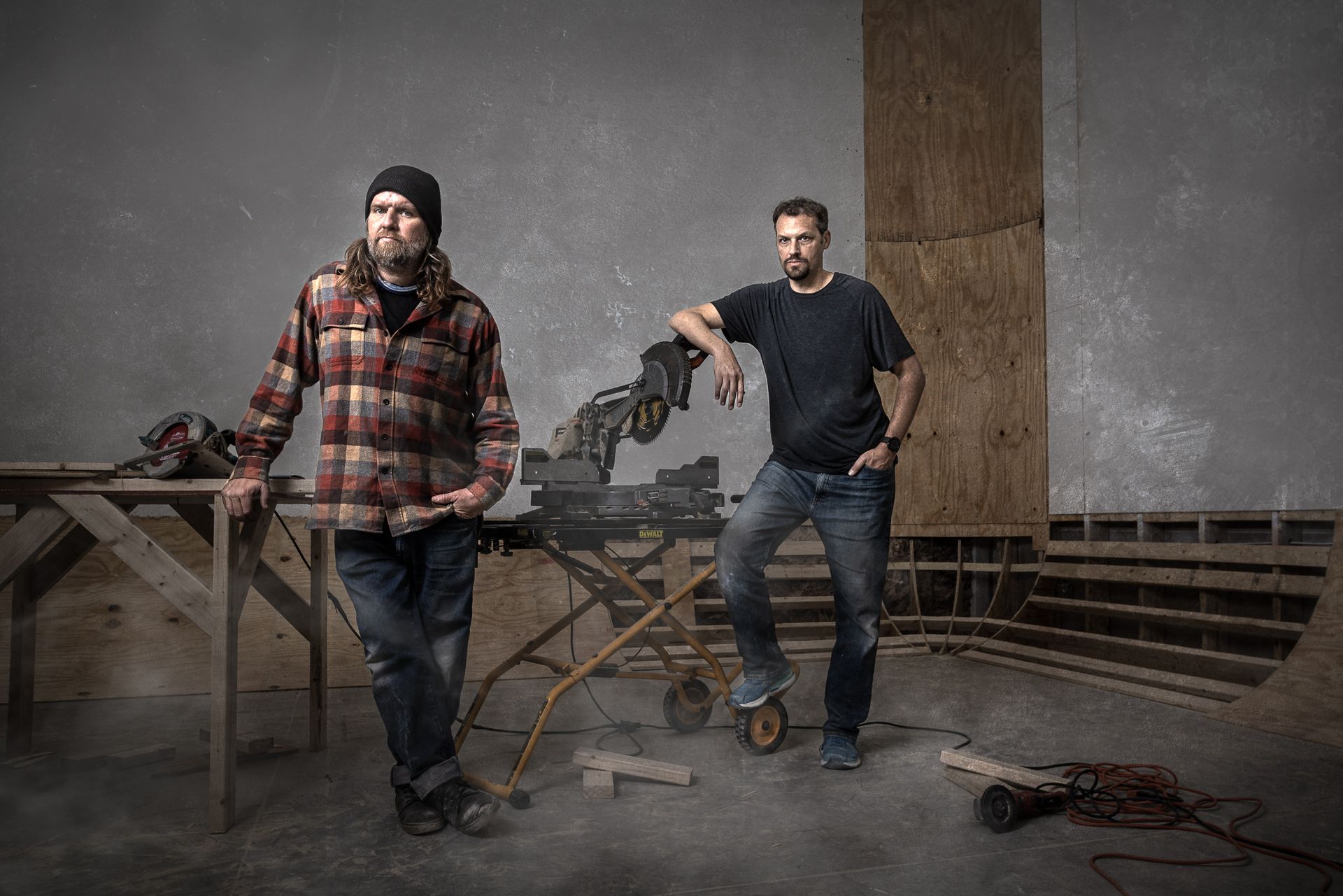 Two construction men standing next to each other in a room building an infinity wall.