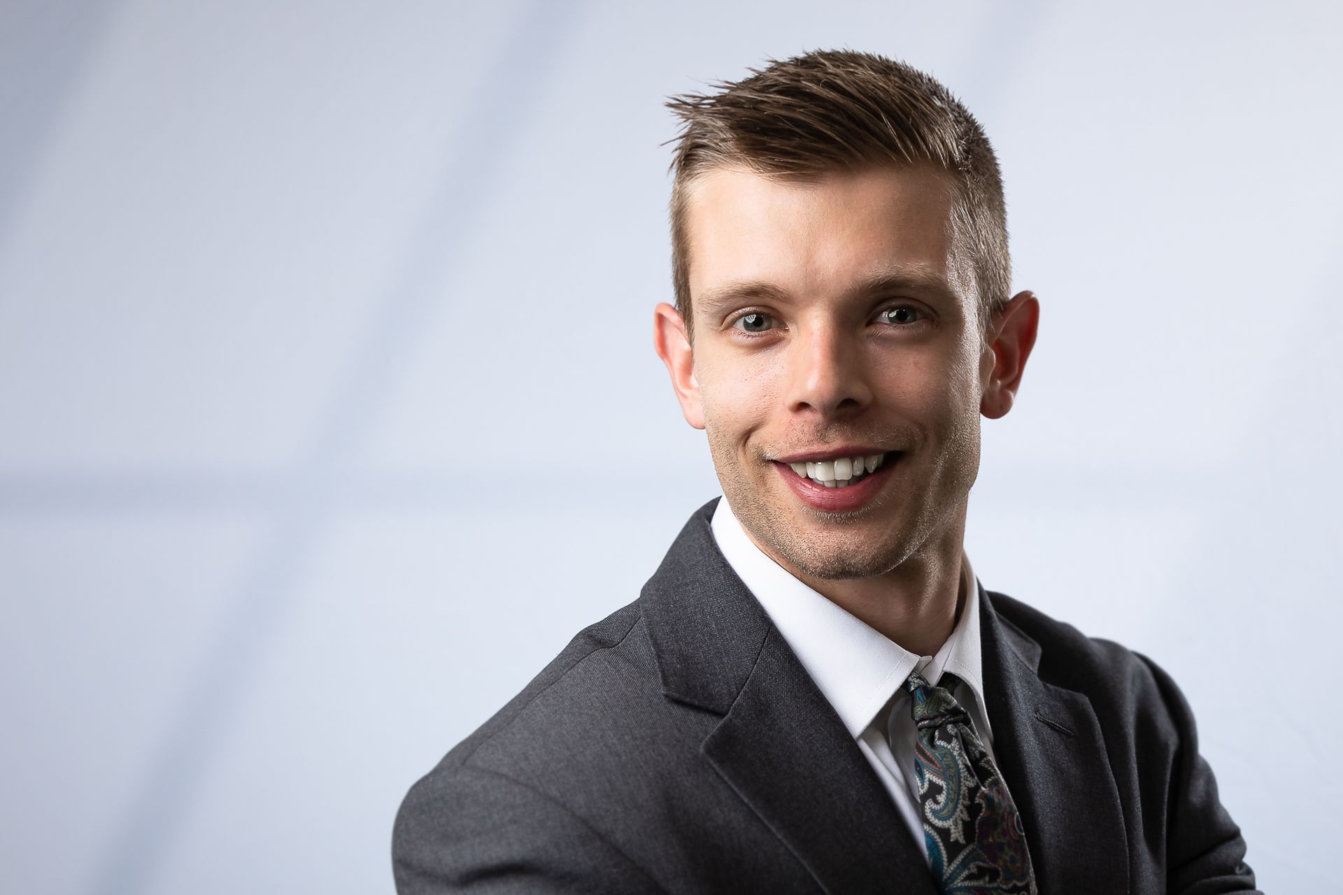 A man in a suit and tie is smiling for the camera