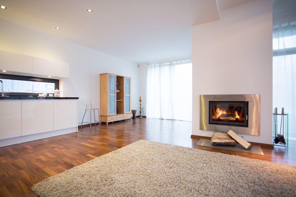 A Modern Open-plan Living Room With a Lit Fireplace — Complete Heating In Huntingfield, TAS