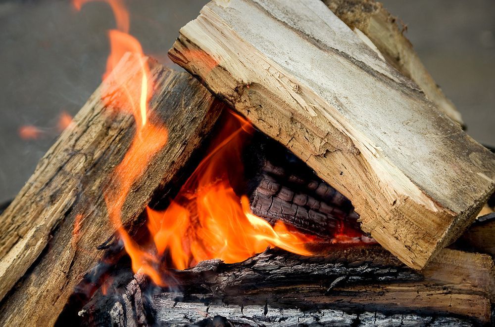 Bright Orange Flames Flicker Between Two Stacked Logs of Firewood — Complete Heating In Huntingfield, TAS
