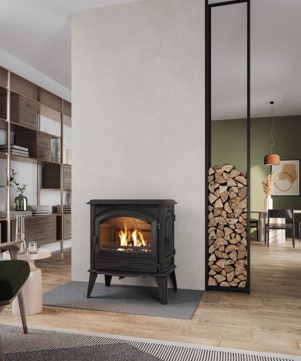 Living Room With a Lit Black Wood Stove, Stacked Firewood, and Open Shelving — Complete Heating In Huntingfield, TAS