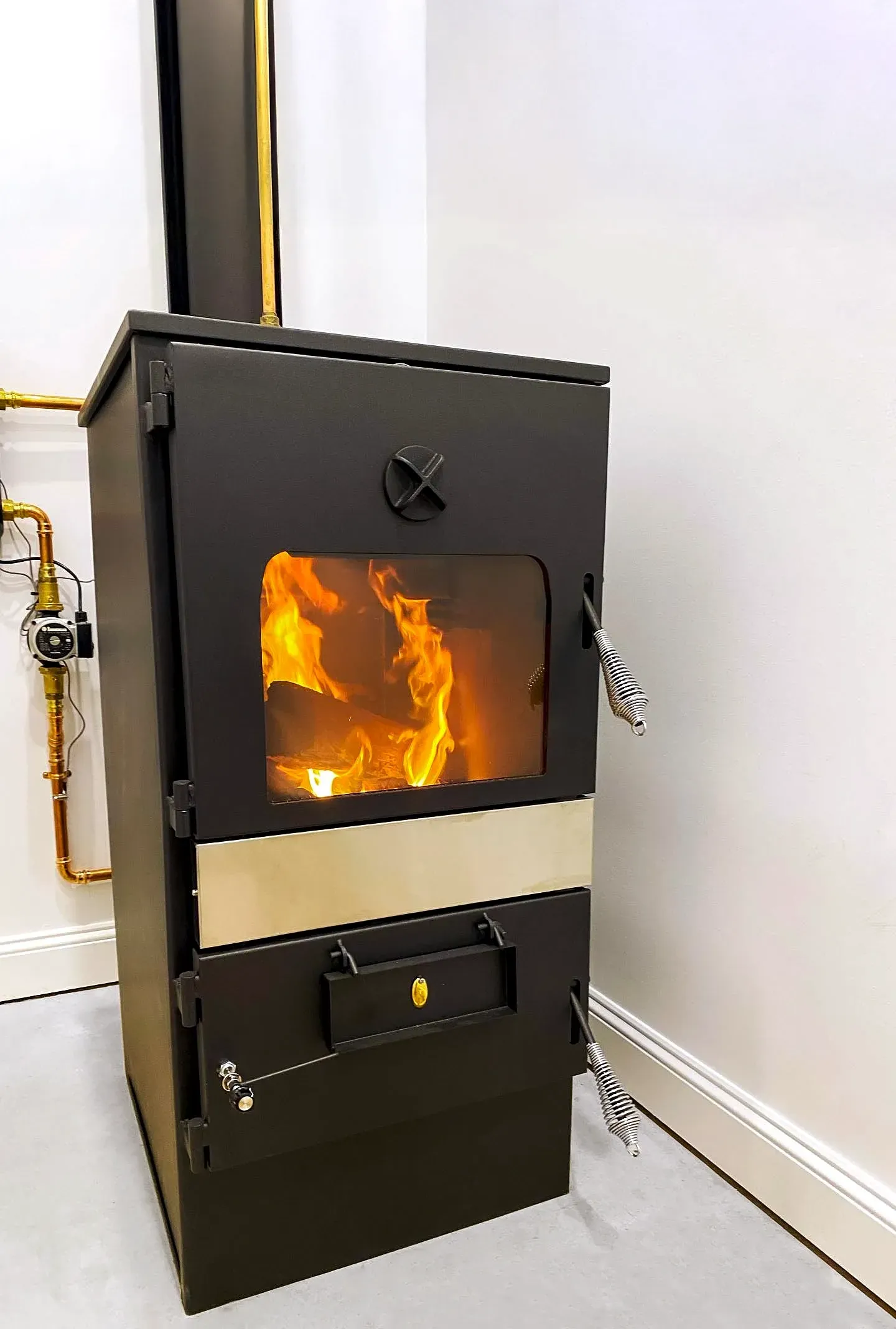 Black Wood-burning Stove With a Lit Fire in a White Room — Complete Heating In Huntingfield, TAS