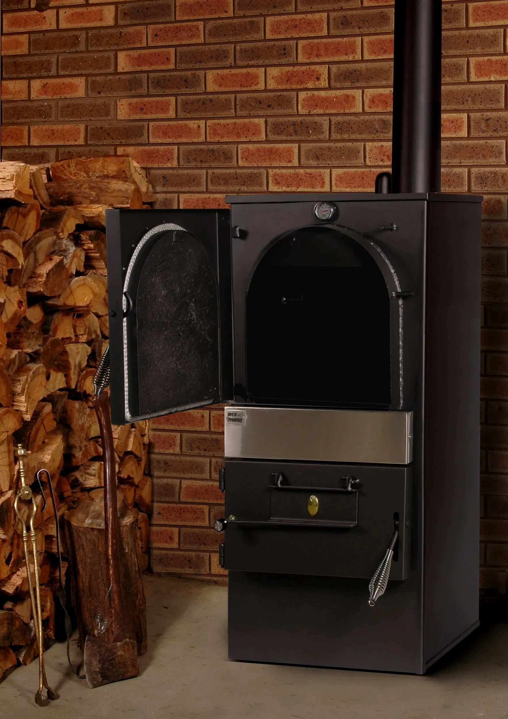 Black Wood-burning Stove With Open Door Beside Stacked Firewood — Complete Heating In Huntingfield, TAS
