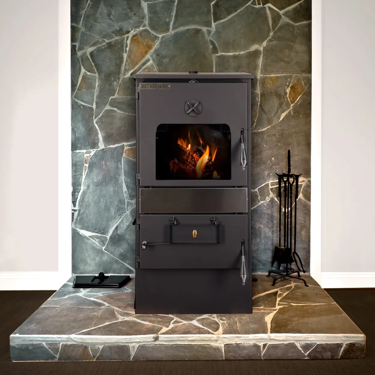 Black Wood Stove With Fire, Set on a Stone Hearth Against a Green Stone Wall — Complete Heating In Huntingfield, TAS